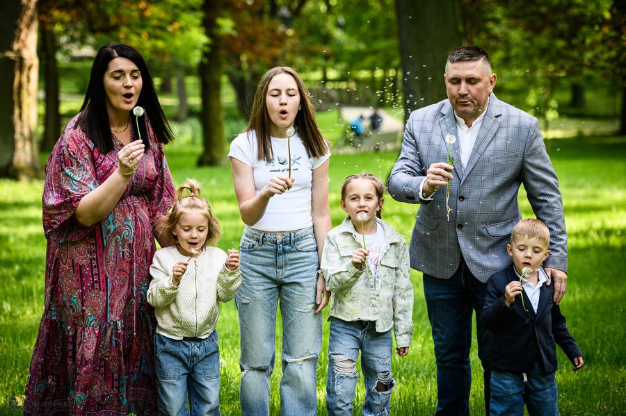Rodzina dmuchająca dmuchawce w parku