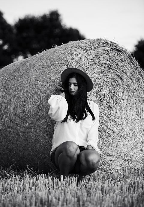 Portret przy beli siana, fotografia czarno-biała
